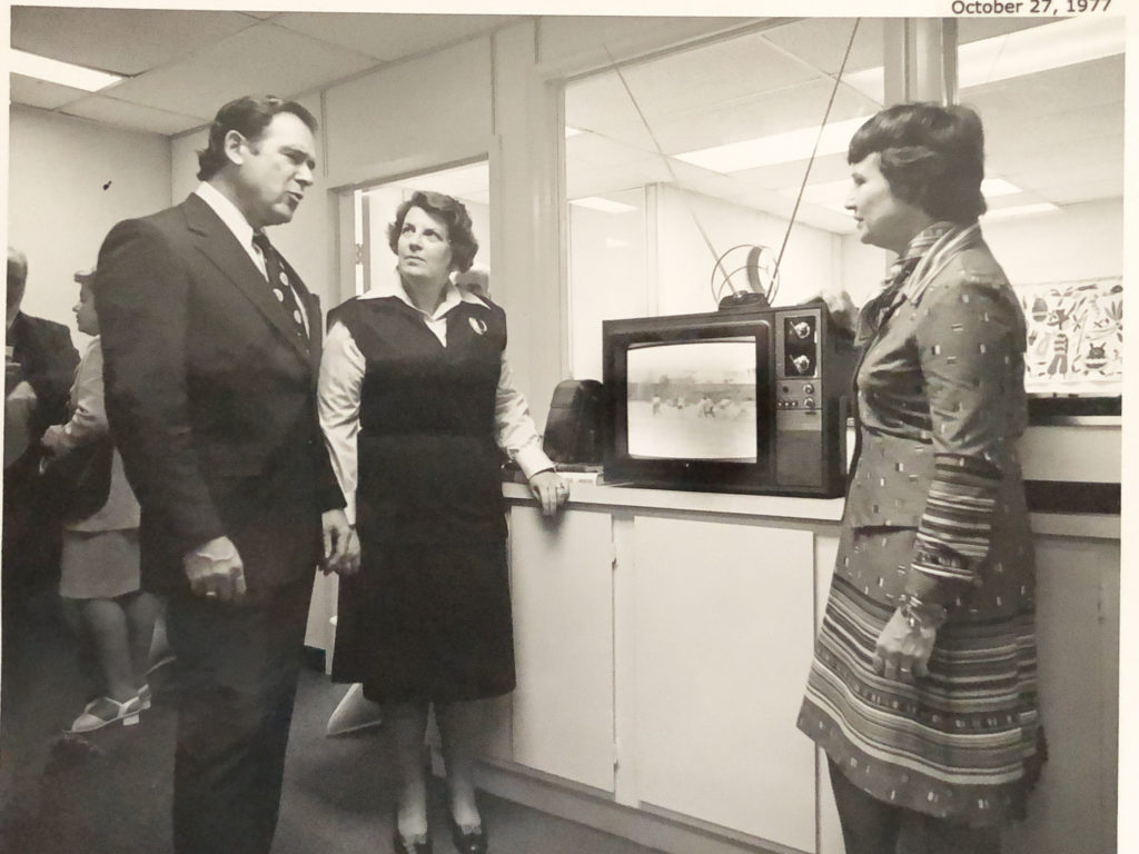 Joan Wilson, 1st Director of OBC (right side) is showing off videos to Lesley Dorman, President of AAFSW and Carl Ackerman, Assistant Secretary for Diplomatic Security
